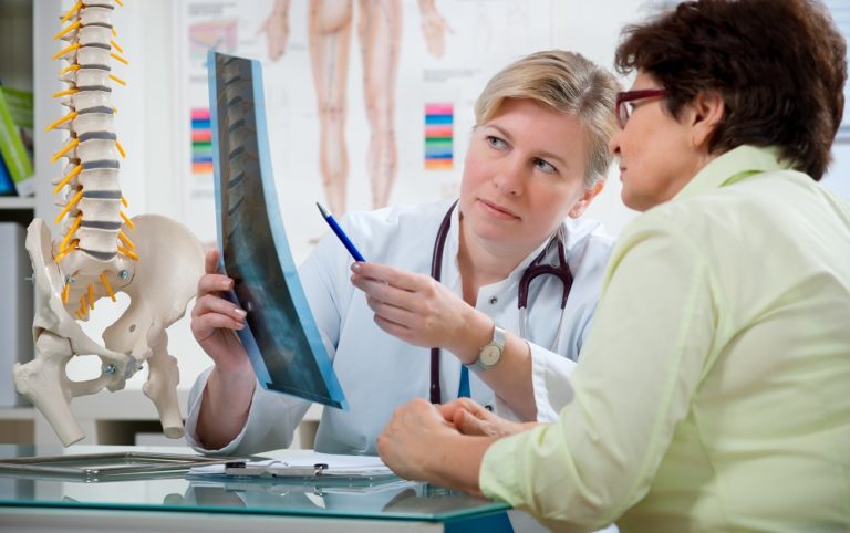 doctor showing spine x-ray to patient