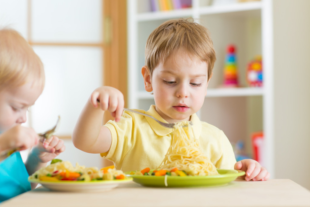 A little boy eating pasta