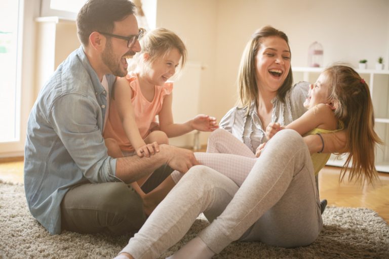 A family of four playing in their living room