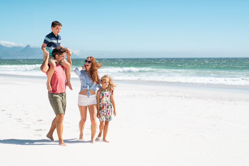A young family walking on the beach on a sunny day