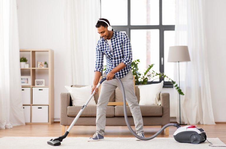 a man vacuuming the carpet