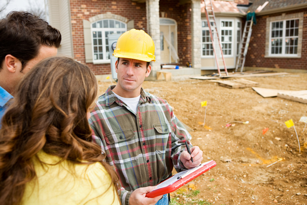 contractor talking and showing progress to couple